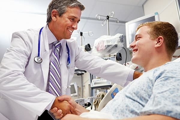 Imagem de um doutor e um paciente felizes e apertando as mãos